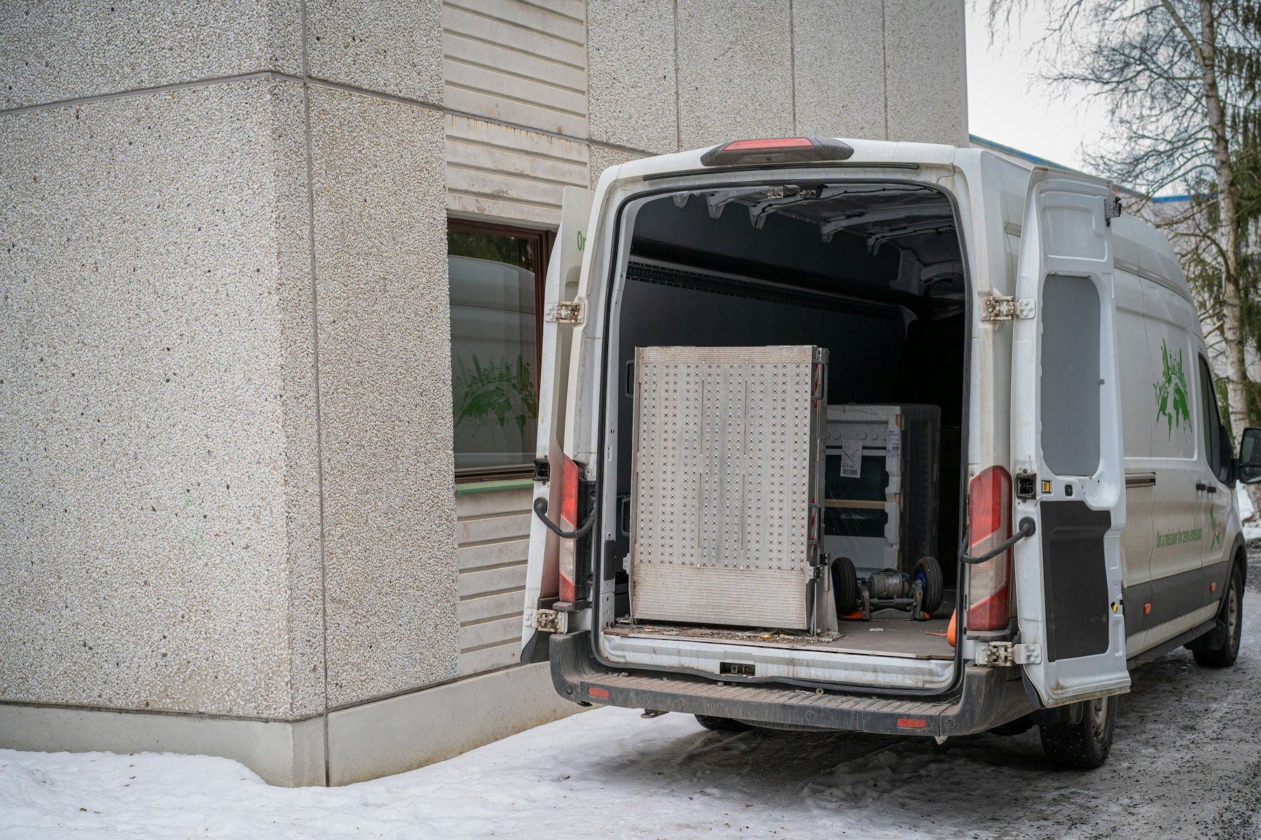 Moving van with its back doors open and appliances inside (reference photo)